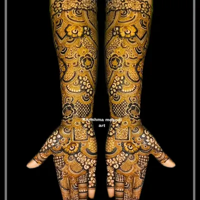 A highly intricate and dense bridal design with a focus on repeating geometric and floral motifs. The use of negative space with dark henna creates a stunning contrast, showcasing exceptional skill and precision.