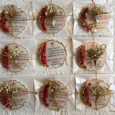 These are the beautifully packaged baptism return favors I created for a client. Each personalized plaque is tied with a delicate ribbon and a sprig of dried flowers, ready to be gifted.