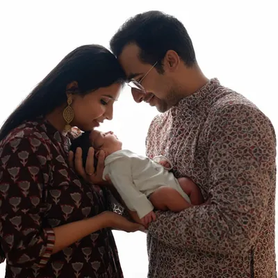 A silhouette-style portrait of new parents admiring their baby. This image beautifully captures the intimate, quiet moment of a new family forming.
