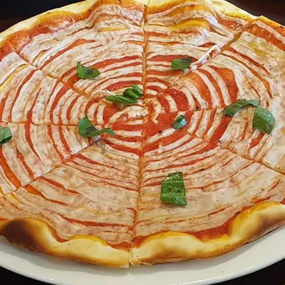 A visually striking pizza with a spiral of tomato sauce and my homemade vegan cheese. This shows that food can be playful and artistic while still being completely healthy and plant-based.