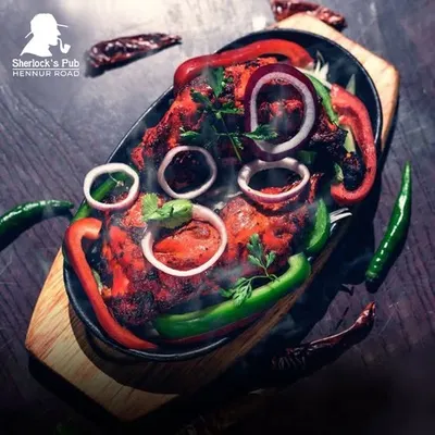 My Tandoori Chicken is served sizzling hot, straight from the tandoor. It's marinated in spices and cooked to perfection, making it a smoky, flavorful dish that pairs perfectly with a cold drink.