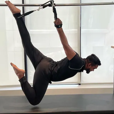 This pose on the Cadillac requires immense core strength and flexibility. It's an example of the advanced bodyweight control we work towards.