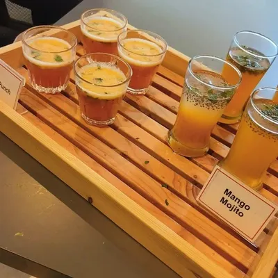 A tray of our refreshing welcome drinks, featuring Mango Mojito and Fruit Punch. These mocktails are a perfect start to any corporate meet or party, especially during the summer.