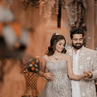 The couple shares a dance during their engagement celebration, dressed in elegant, coordinated outfits. This shot captures the romantic atmosphere of the event, with soft lighting and beautiful decor in the background.