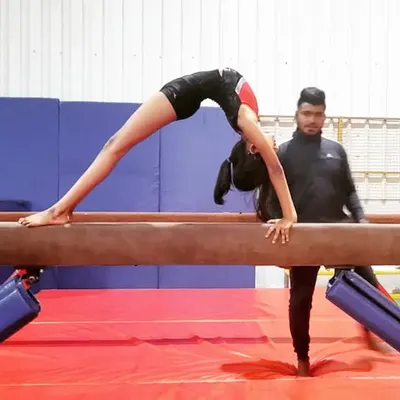 I'm spotting a student as she practices a back walkover on the low beam. This builds her confidence before moving to the high beam.