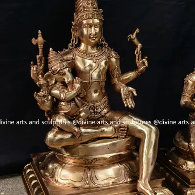 A magnificent bronze sculpture of Lord Shiva with his son Ganesha on his lap. This is part of a larger Shiva Parivaram set, symbolizing paternal love and divine protection.