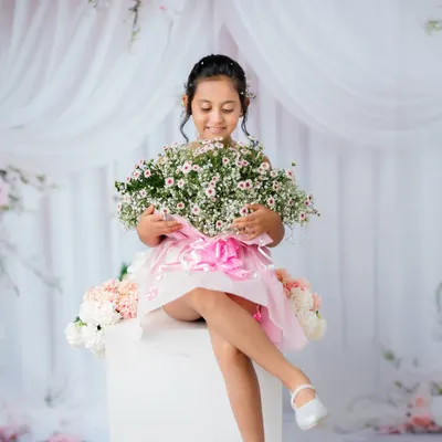 A beautiful portrait of an older child in a dreamy, floral studio setup. She looks like a little princess.