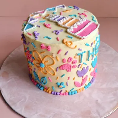 A close-up of the detailed piping on Theo's cake. We hand-pipe every flower, paw print, and letter to make your pet's cake truly special.