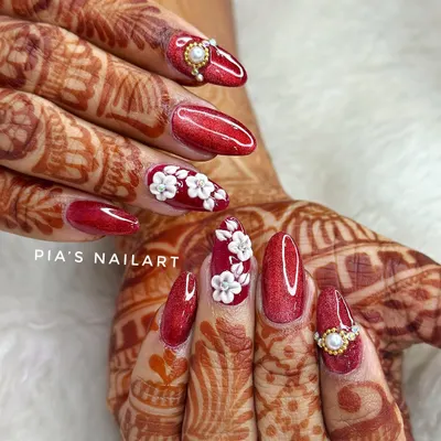 A classic bridal look for a reason. This set features a rich, glittery red base with hand-sculpted 3D white acrylic flowers and elegant pearl and diamond accents. Perfect for the traditional bride.