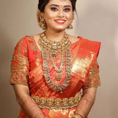A quintessential South Indian bridal look. This bride wanted a classic and grand appearance, which we achieved with a rich red silk saree and layers of antique-finish temple jewelry.