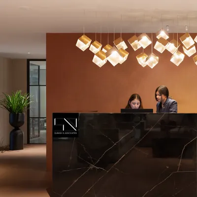 The reception at Jubilee Walk Headquarters, designed to be the first point of contact with the brand's ethos. The solid black marble desk, complemented by a cascade of geometric pendant lights, establishes an immediate sense of modern luxury and professionalism.