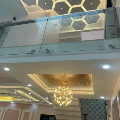 A view of a double-height ceiling space featuring a glass bridge and a hexagonal-patterned false ceiling on the upper level. This design adds architectural interest and a sense of luxury.