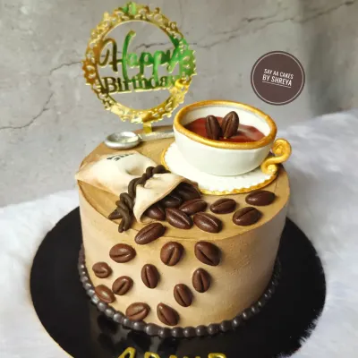For those who love their cake like their coffee: rich and strong. This design features an edible, handcrafted coffee cup, spilling over with fondant coffee beans, making it the perfect birthday cake for a caffeine aficionado.
