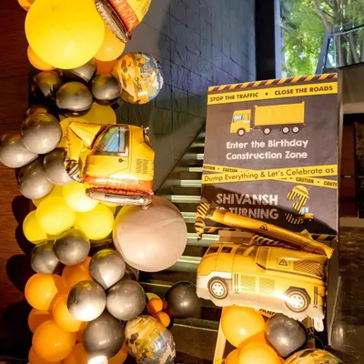 Welcome to the construction zone. I set the scene right from the entrance with a custom sign, truck-shaped mylar balloons, and a yellow and black balloon garland to get the little builders excited for the party.
