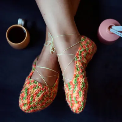 Our ballet-style crochet booties are perfect for feeling cozy and elegant at home. The multi-colored yarn creates a beautiful pattern, and the ties can be laced up your ankle.
