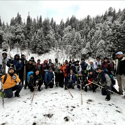 Our trekking group posing in the snow covered forests on the way to the Kedarkantha summit. The camaraderie and shared challenge make the cold totally worth it.