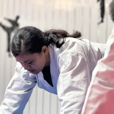 A female student focused during a tough training drill. We teach that in martial arts, and in life, there are no excuses, only the power to keep moving forward.