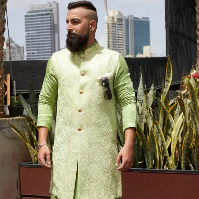 A festive masterpiece in pastel green. This layered set features a waistcoat with intricate, mesmerizing patterns over a matching kurta, perfect for the season of celebration.