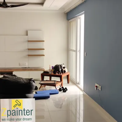 A modern living room with a sophisticated grey-blue accent wall contrasting with clean white walls. This two-tone approach adds depth and style.