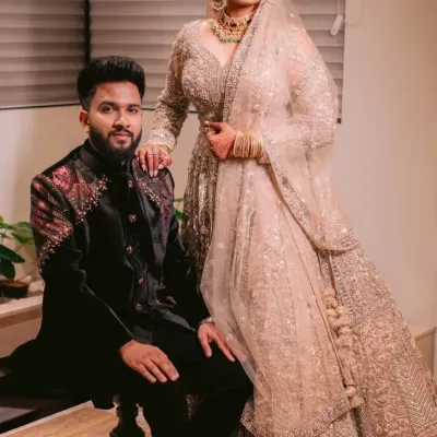 In this portrait, the groom's structured black velvet sherwani with its detailed embroidery provides a beautiful contrast to the bride's shimmering champagne lehenga. I designed his outfit to be strong and regal, yet complementary.
