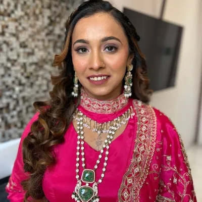 A perfect example of soft glam for a wedding guest. This look features a warm, shimmery eyeshadow, glowing skin, and a complementary lip color, all designed to enhance her features and match her vibrant pink outfit.