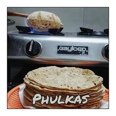 The heart of my kitchen: making soft, fluffy Phulkas. Each one is cooked on the tawa and then puffed up on an open flame, ensuring they reach you fresh and warm.