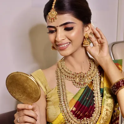 This stunning South Indian bridal look, created by our students, showcases the intricate details we teach, from the perfect winged eyeliner to the traditional jewelry placement.
