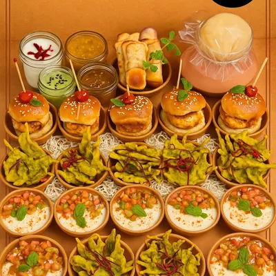 This chaat platter is a feast for the senses, showcasing the sheer variety we can offer. It features miniature Vada Pavs, Palak Patta Chaat, and Kachoris, providing a comprehensive taste of Mumbai's best street food in one beautifully arranged spread.