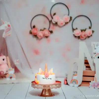 The magical unicorn-themed setup is ready for the birthday girl. I coordinate every detail, from the floral hoops and 'ONE' letters to the adorable unicorn cake.