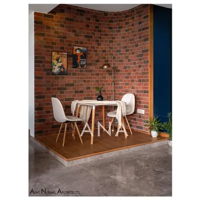 This breakfast deck in Apartment 704 was created by repurposing underutilized space. A curved raw brick wall provides a textured backdrop, creating a cozy and distinct zone for casual dining.