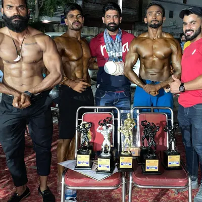 The whole team celebrating after a successful competition. Multiple students, multiple trophies. This is the result of our shared commitment to excellence in natural bodybuilding.