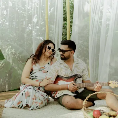 A relaxed picnic-themed shot where the groom plays the guitar for his bride-to-be. This setup is perfect for a casual and musical couple.