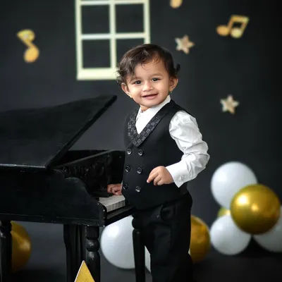 Our little maestro, looking dapper and ready for his piano debut. This music-themed first birthday shoot combines classic style with playful fun.