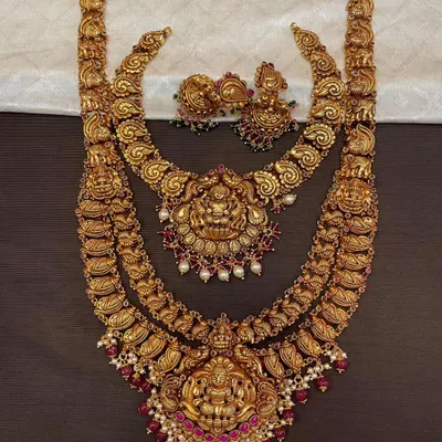 This is a complete 92.5 silver, gold-plated bridal combo set. It features a short necklace, a long haram, and matching earrings, all with intricate temple-inspired designs.