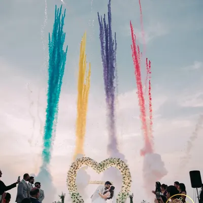 A spectacular destination wedding moment, with colorful fireworks lighting up the sky as the couple shares a kiss.