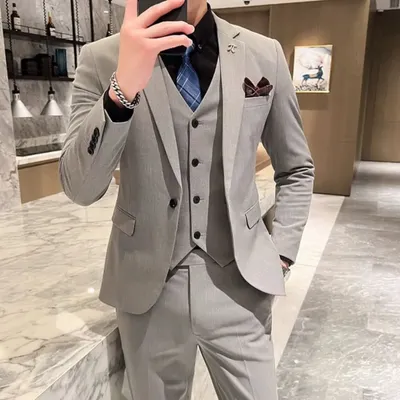 A customer looking sharp in a classic light grey three-piece suit. This is a versatile outfit that works perfectly for a formal day event or a business meeting.