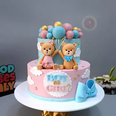 A beautiful two-tier "Boy or Girl?" gender reveal cake, featuring cute teddy bears and a cascade of pink and blue balloons.