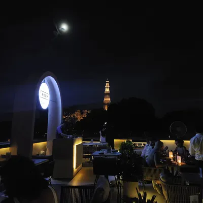 An evening on the terrace, where the moon and the Qutub Minar share the skyline. This is the serene, magical atmosphere I strive to create for every guest.