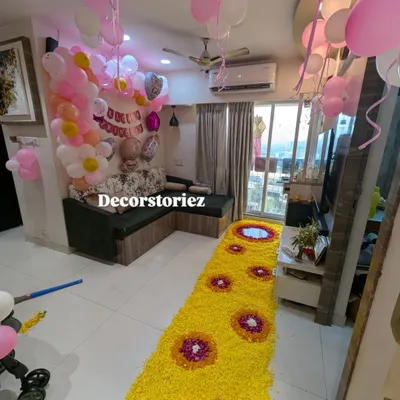 A grand welcome for a baby girl, featuring a long, beautiful flower petal runner leading into a room filled with pink and white balloons. This setup creates a stunning first impression.