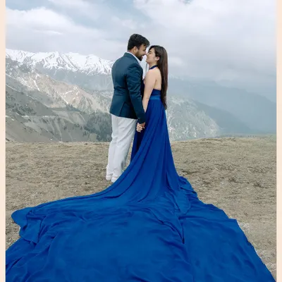 A breathtaking shot in Gulmarg, Kashmir, where the bride's flowing blue gown contrasts stunningly with the snow-capped mountains. This is the kind of epic, cinematic portrait that a destination like Kashmir makes possible.