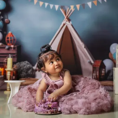 A princess enjoying her first birthday cake in our whimsical teepee setup. We love combining themes to create a truly unique cake smash photoshoot.