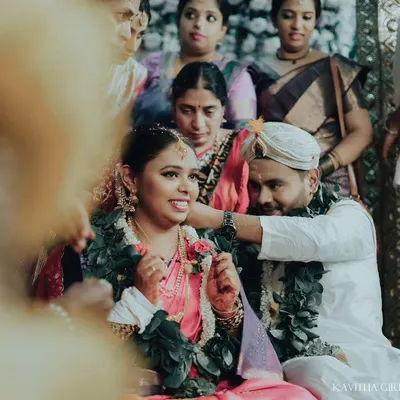 A candid moment from a South Indian wedding ceremony, capturing the bride's happy expression as the groom performs a ritual. These are the unscripted memories I love to freeze.