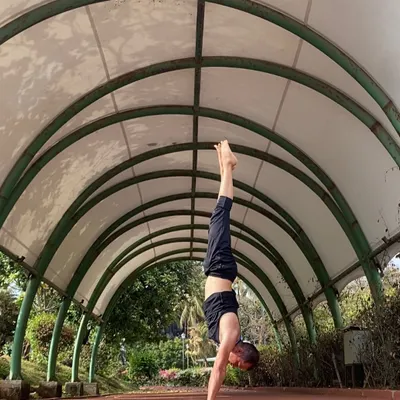 A stable handstand (Adho Mukha Vrksasana) requires focus and full-body engagement. This pose, captured under a walkway, highlights the alignment and control that we work towards in my classes.