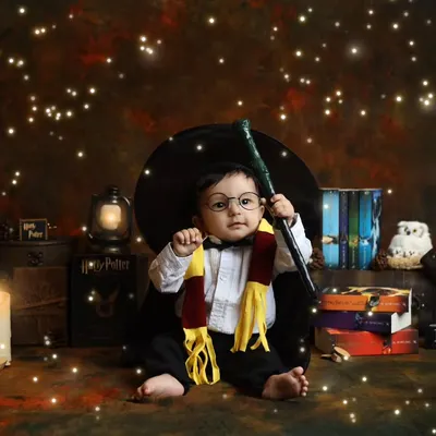 Your little one is ready to cast a spell in this magical Harry Potter themed toddler shoot. Seated among glowing candles and classic books, this setup captures the wonder of the wizarding world.