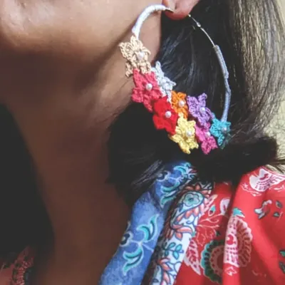 Here are our signature floral crochet hoop earrings being worn. You can see how the vibrant, multi-colored flowers create a beautiful statement piece that is still light and easy to wear.
