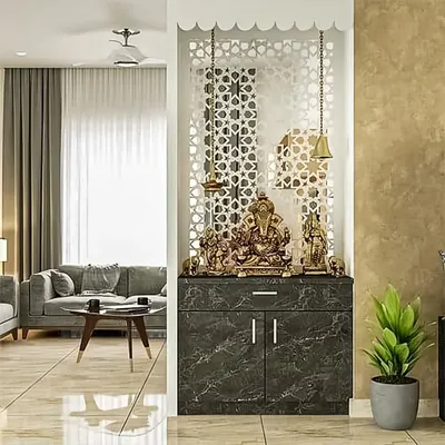 A modern pooja unit created in an alcove with a beautiful jaali partition. The marble-finish cabinet and hanging brass bells create a divine corner that is beautifully integrated into the living area.