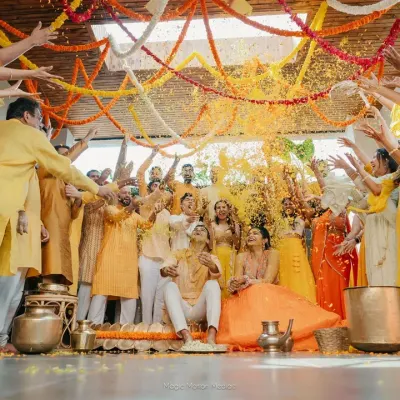 The ultimate Haldi celebration! A joyful couple gets showered with marigold petals by their friends and family in a moment of pure, unadulterated fun.