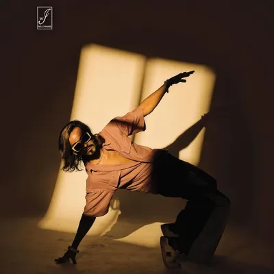 A dynamic shot from our shadow-play series. The model's pose interacts with the projected light, creating a fusion of dance, form, and shadow.