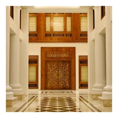 The main entrance of a Kerala-style luxury home, featuring a meticulously hand-carved wooden door set within a larger wooden frame. This design highlights our expertise in traditional woodworking and creating grand entryways.