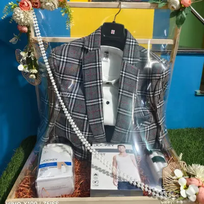 A modern and stylish way to pack a groom's outfit. This checked blazer and shirt set is arranged with innerwear and a deodorant, making it a complete and practical gift hamper.